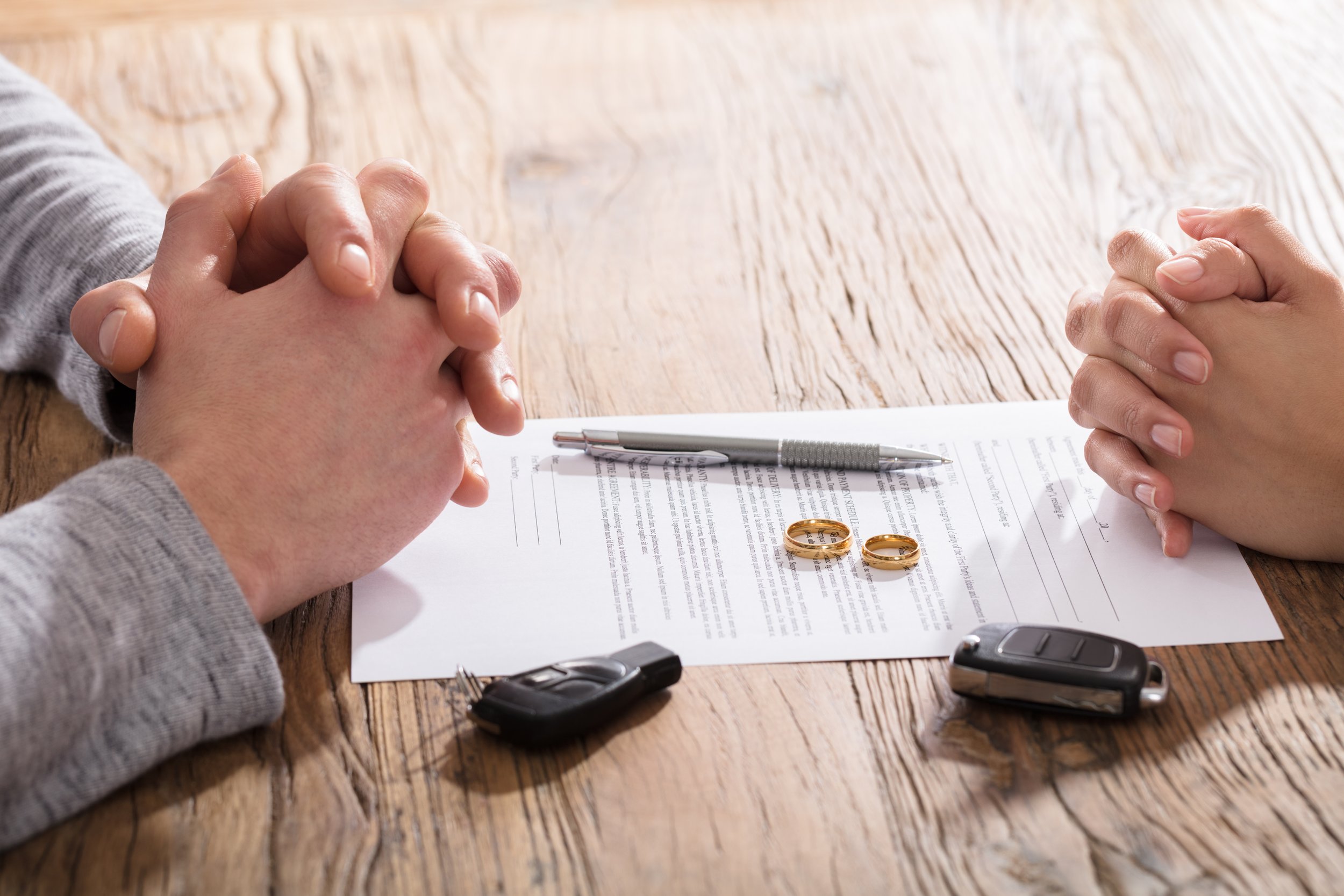 Couple's Hand On Divorce Agreement Wit Car Keys
